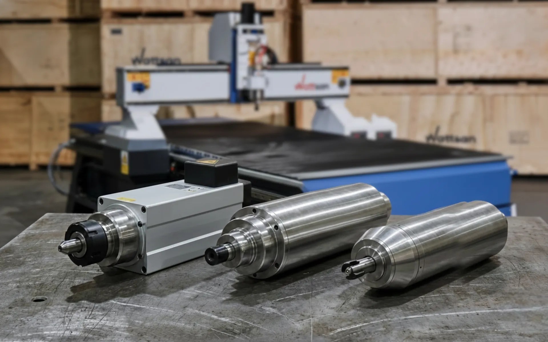 Шпиндели GDZ, GDK и DX лежат на столе на фоне станка с ЧПУ Wattsan.